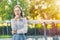 Portrait Asian smart look business woman standing thinking hand at chin on green outdoor background