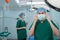 Portrait of Asian surgeon with medical mask standing in operation theater at a hospital. Team of Professional surgeons. Healthcare