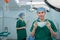 Portrait of Asian surgeon with medical mask standing in operation theater at a hospital. Team of Professional surgeons. Healthcare