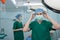 Portrait of Asian surgeon with medical mask standing in operation theater at a hospital. Team of Professional surgeons. Healthcare