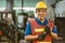 Portrait Asian technician engineer male hand holding giant wrench happy smile. heavy industry employee enjoy working.good labor