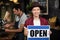 Portrait of a asian waiter showing open sign