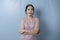 A portrait of Asian woman folding her arms looks upset, wearing modern kebaya  by blue background