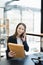 Portrait of a Asian woman lawyer studying lawsuit a for a client using smartphone , documents and computer to work