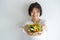 Portrait of asian woman smiling. woman eating salad, focus her hand on white background