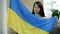 Portrait of an Asian woman with the Ukrainian flag in her hands. Protest against the war in Ukraine and Russian