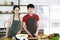 Portrait, Asian young couple. Are standing with smile cooking in the kitchen. Prepare and make cook salad for food together happil