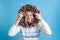 portrait of an Asian young woman looking through a Christmas wreath of tree branches, cones and ornaments