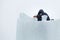 Portrait of an assembler worker in a jacket with a hood at the construction of an ice camp