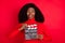 Portrait of astonished dark skin person open mouth hands hold clapboard isolated on red color background