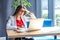 Portrait of attentive beautiful stylish brunette young woman in glasses sitting and reading something important on her laptop