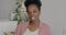 Portrait of attractive African American woman smiling standing in light kitchen room looking at camera