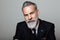 Portrait of attractive bearded gentleman wearing trendy suit over empty gray background. Studio shot, fashion concept.