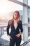 Portrait of attractive blonde wearing elegant formal suit standing in airport terminal