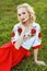 Portrait of attractive blonde woman with makeup and curly hairstyle in stylish red white dress posing with tenderness and passion