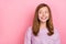 Portrait of attractive cheerful curious teen girl thinking copy space ad isolated on pink pastel color background