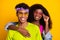 Portrait of attractive cheerful fashionable funky couple embracing good look isolated over bright yellow color