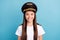 Portrait of attractive cheerful girl captain aviator wearing hat  over bright blue color background