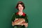 Portrait of attractive cheerful girl holding festal tree balls advent newyear eve fairy isolated over green color