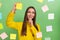 Portrait of attractive cheerful minded girl sticking copy space memo papers on wall isolated over green pastel color