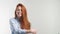 Portrait of attractive cheerful redhead girl with flying curly hair smiling laughing looking at camera over white