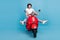 Portrait of attractive comic childish cheerful woman riding moped having fun fooling isolated over bright blue color