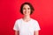 Portrait of attractive content cheerful girl wearing white tshirt isolated over vibrant red color background