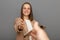 Portrait of attractive delighted positive brown-haired woman wearing jacket holding clipboard with documents, handshaking, deal,