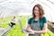 Portrait of an attractive farmer in a greenhouse using laptop