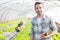 Portrait of an attractive farmer in a greenhouse using tablet