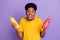 Portrait of attractive funky cheerful guy holding ketchup bottles licking lip snack isolated over violet purple color