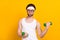 Portrait of attractive funky guy nerd doing work out muscles development isolated over bright yellow color background