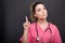 Portrait of attractive lady doctor holding finger like having id