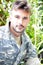 Portrait of attractive male soldier wearing camouflage uniform looking at camera