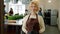 Portrait of attractive mature blonde in apron smiling indoors in cookery school