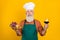 Portrait of attractive minded bearded grey-haired man holding in hand wine snack choosing menu isolated over bright