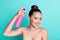 Portrait of attractive naked nude cheerful girl using spray domestic coiffure prepare  over bright teal