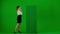 Portrait of attractive office girl on chroma key green screen. Woman in skirt and blouse using green board as touch