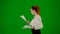 Portrait of attractive office girl on chroma key green screen. Woman in skirt and blouse walking reading paper documents