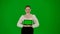 Portrait of attractive office girl on chroma key green screen. Woman in skirt holding tablet with mockup and talking at