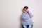 Portrait of an attractive overweight woman with hat and sunglasses in a studio.