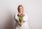 Portrait of an attractive overweight woman with tulips in studio on a white background.