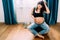 Portrait of attractive pregnant woman smoothing belly and stroking hair