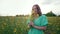 Portrait of attractive rural woman with bouquet in rapeseed field. Elegant girl in retro dress, countryside nature place