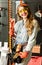 Portrait of the attractive salesgirl with long blonde hair and yellow glasses in home improvement store with pliers