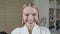 Portrait of attractive smiling woman blond. In a white bathrobe after the procedure. Cosmetology and SPA center concept.
