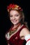 Portrait of attractive smiling woman in traditional costume in ukranian national wreath with flowers