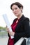 Portrait attractive suited woman holding rolled up paper