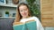 Portrait of attractive teenage girl reading book at home smiling turning pages
