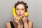 Portrait of attractive woman in glasses holding lemon and banana